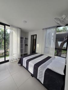 a bedroom with a bed and a large window at El Ensueño - Rest House in La Mesa