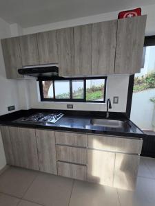 a kitchen with a stove and a sink and a window at El Ensueño - Rest House in La Mesa
