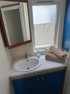 a bathroom with a sink and a window and a mirror at Domki GAMA in Gąski +50 photos