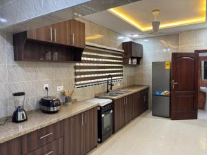a large kitchen with wooden cabinets and a refrigerator at Grand View Lodge in Trofwi +13 photos