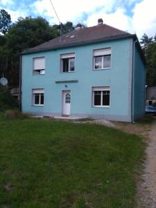 a blue house with a white door and a yard at Chambre d'hôtes dans un écrin de verdure in Dambach