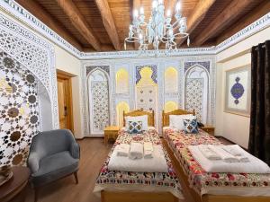 a bedroom with two beds and a chandelier at Basilic Boutique Hotel in Bukhara