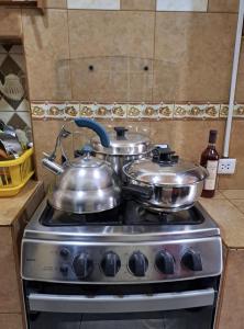 two pots and pans on a stove in a kitchen at VillaHouse - Huaraz in Huaraz
