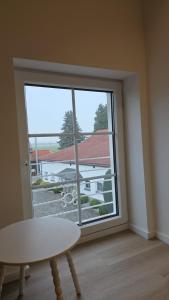 a room with a large window with a table and a table at Hof Busen Malibu in Mönchengladbach