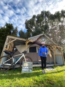 a woman is standing in front of a tent at Glamping Mañihueico in Contao