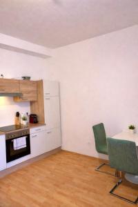 a kitchen with a table and chairs in a room at Rohrbach Apartments in Ternitz