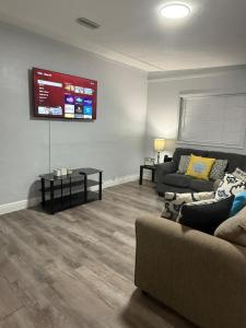 a living room with a couch and a tv on the wall at Relaxing 1BR Apartment in Ormond Beach Large Patio in Ormond Beach