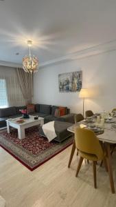 a living room with a couch and a table at Luxury 127m Apartment in Jardins de Carthage with Balcony, Private Parking & Prime Location in Sidi Daoud