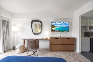 a hotel room with a desk and a mirror at Ala Moana Hotel _ Ocean view with balcony in Honolulu