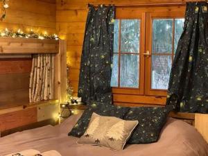 a bedroom with a bed and a window with christmas lights at Fancy Fireflies Cabin in Hayward