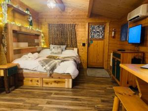 a bedroom with a bed in a wooden cabin at Fancy Fireflies Cabin in Hayward