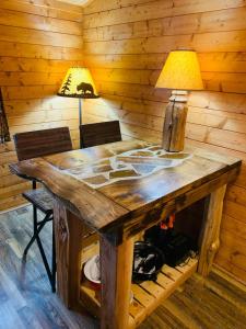 a wooden table in a room with a lamp at Fancy Fireflies Cabin in Hayward +21 photos