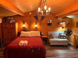 a bedroom with a bed and a couch and a chandelier at The Timberjack in Hayward