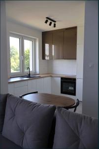 a kitchen with a table and a couch in a room at Bee happy apartament Kępno in Kępno