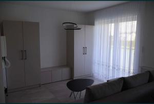 a living room with a couch and a table and a window at Bee happy apartament Kępno in Kępno