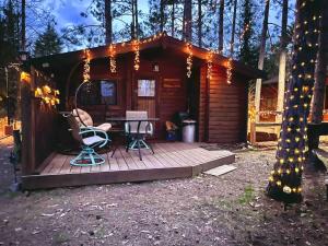 a cabin with a table and chairs on a deck at Lakeshore Lily Pad in Hayward