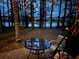 a table and a chair on a deck with lights at Lakeshore Lily Pad in Hayward +20 photos