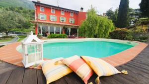 a swimming pool with a lantern and two pillows next to a house at B&B POGGIO CAIAR in Caprino Veronese