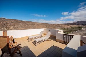 eine Terrasse mit zwei Stühlen und Blick auf einen Hügel in der Unterkunft Salitre in Ajuy