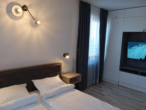 a bedroom with a bed and a flat screen tv at Monfort Studio in Bansko