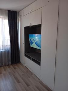 a living room with a tv in a white cabinet at Monfort Studio in Bansko