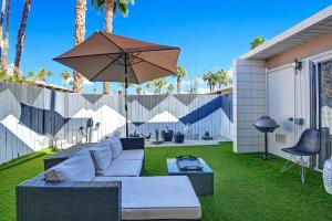 a patio with a couch and an umbrella at Ocotillo Art Bungalow in Palm Springs