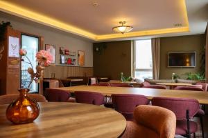 a restaurant with wooden tables and purple chairs at Airport Hotel Jägerhof Weeze in Weeze