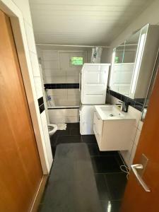 a small bathroom with a sink and a toilet at Large room, shared kitchen and bath, near station in Bolligen