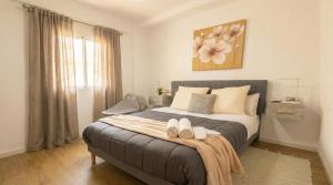 a bedroom with a bed with two shoes on it at Apartalux Playa Diva in Grao de Castellón