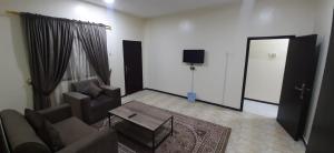 a living room with a couch and a table and a mirror at شقة مفروشة غرفة وصالة بالمبرز in Al Mubarraz