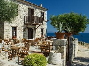 a restaurant with tables and chairs in front of a building at Sea and Stone Villa in Afitos