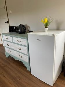 a white dresser with a vase on top of it at A Costa, Valle del Mendo in Oza dos Ríos