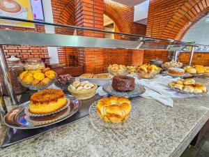 a buffet of cakes and pastries on a table at Hotel Verdes Mares in Ouro Branco