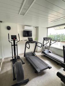 a gym with two treadmills and a treadmill and a television at Max Savassi Prime in Belo Horizonte
