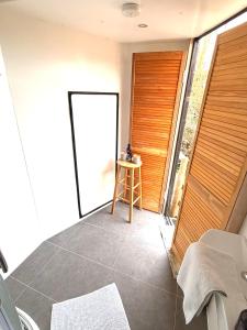 a room with a door with a stool and a table at Wiltshire Weavers Hut in Chippenham