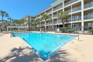 a swimming pool in front of a apartment building at Grand Caribbean East Poolside Palms in Pensacola