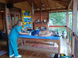 a woman standing next to a man laying on a bed in a cabin at Jaibaná Spa in Támesis