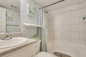 a white bathroom with a sink and a shower at 7 Mi to Downtown Fun! Spacious Augusta Condo in Augusta +16 photos