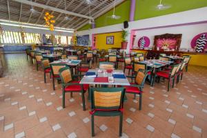 a dining room with tables and chairs in a restaurant at Decameron Los Cocos - All Inclusive in Rincon de Guayabitos
