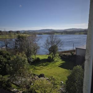 a view of a body of water with a house at Lochmaben in Lochmaben