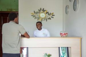 a man standing at a counter looking in a mirror at The city Block Apartment in Bujumbura