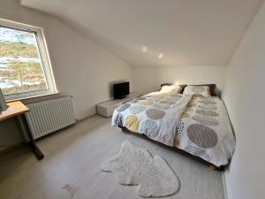 a bedroom with a bed and a desk and a window at Apartment Doroteja in Podplat