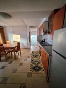 a kitchen with a table and a refrigerator at Apartment Doroteja in Podplat +18 photos