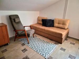 a living room with a couch and a chair at Apartment Doroteja in Podplat