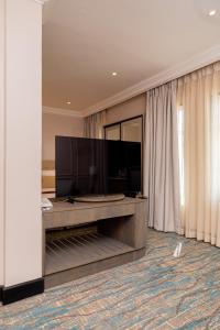 a living room with a flat screen tv on a table at Sunbird Mzuzu in Katoto