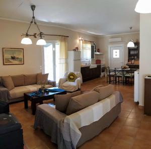 a living room with a couch and a table at Villa Freedom - Koutsoubri Beach Evia in Agriovótanon +28 photos