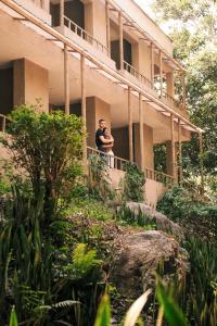 two men standing on a balcony of a building at Hotel Hukumeizi Minca in Minca