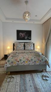 a bedroom with a bed and two lamps and two shoes at Luxury 127m Apartment in Jardins de Carthage with Balcony, Private Parking & Prime Location in Sidi Daoud