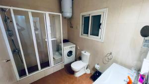 a bathroom with a toilet and a washing machine at Stay Ra3 Suites in Cairo +63 photos