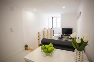 ein Wohnzimmer mit einem Sofa und einer Vase mit grünen Äpfeln in der Unterkunft Light of Lisbon Apartments I in Lissabon